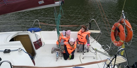 Powiększ grafikę: Widok z góry przedstawiający trzy uczennice na łódce podczas rejsu