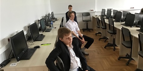 Powiększ grafikę: Troje uczniów w sali komputerowej.