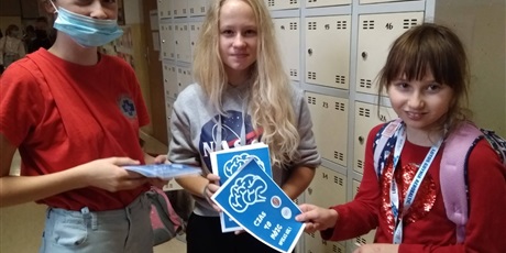 Powiększ grafikę: Trzy uczennice Koła Pierwszej Pomocy rozdają na szkolnym korytarzu ulotki na temat udaru mózgu