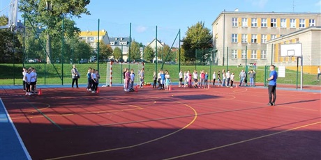 Powiększ grafikę: Na boisku szkolnym uczniowie przygotowują się do wyścigu rzędów